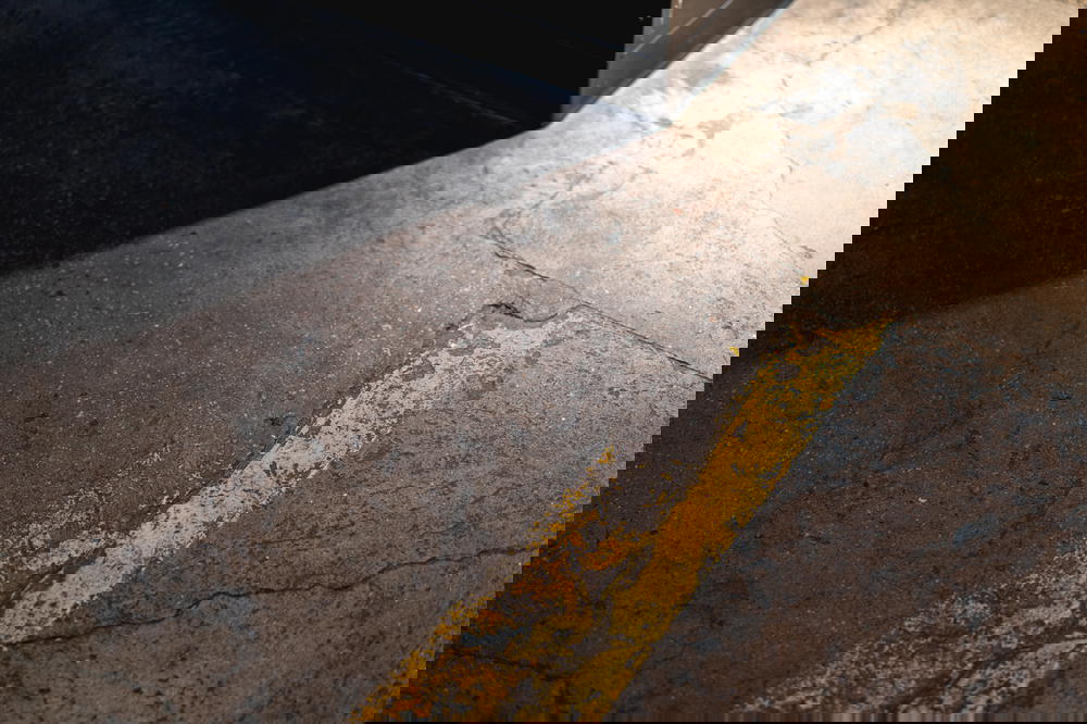 Faded painted yellow line on industrial floor of former warehouse