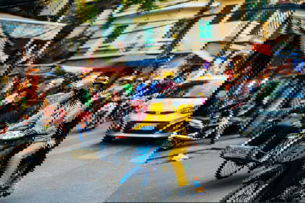 A woman riding a motorbike on a busy street in Hanoi.