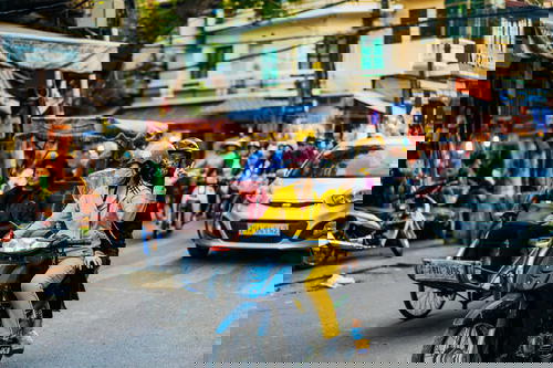A woman riding a motorbike on a busy street in Hanoi.