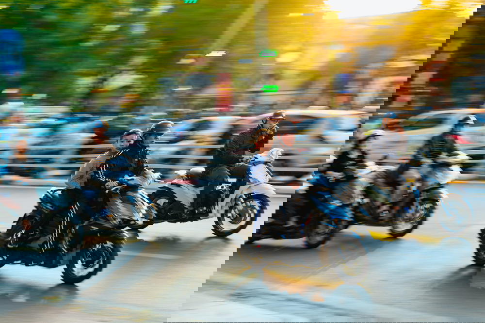 A group of people riding motorcycles on the busy streets of Hanoi, Vietnam.