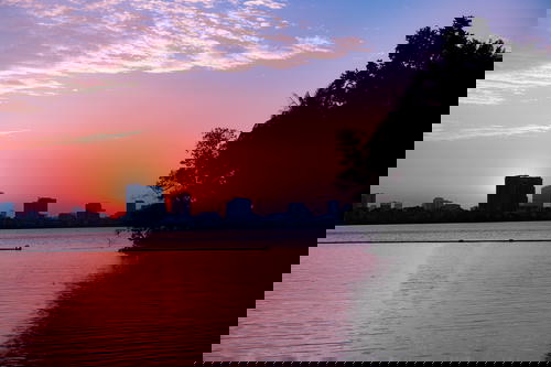 The sun is setting over a lake in Hanoi.