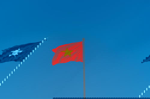 A Vietnam flag flutters against a Hanoi skyline.