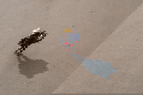 An aerial view of a woman walking down a street in Hanoi, Vietnam.