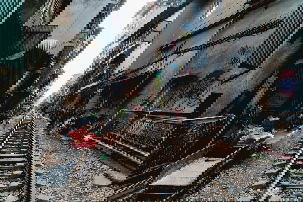 A narrow alleyway in Hanoi, Vietnam with a train track.