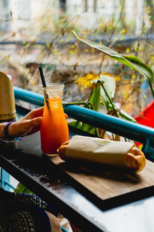 A woman enjoying a drink at a table in Hanoi, Vietnam.