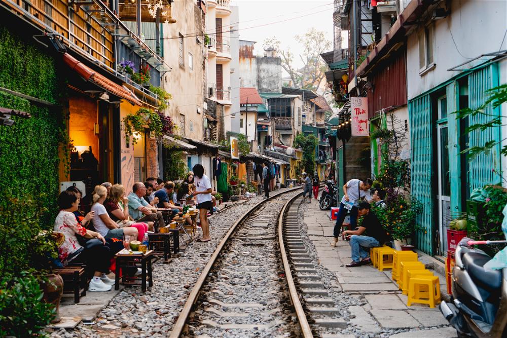 People are sitting on a train track in Hanoi, Vietnam.