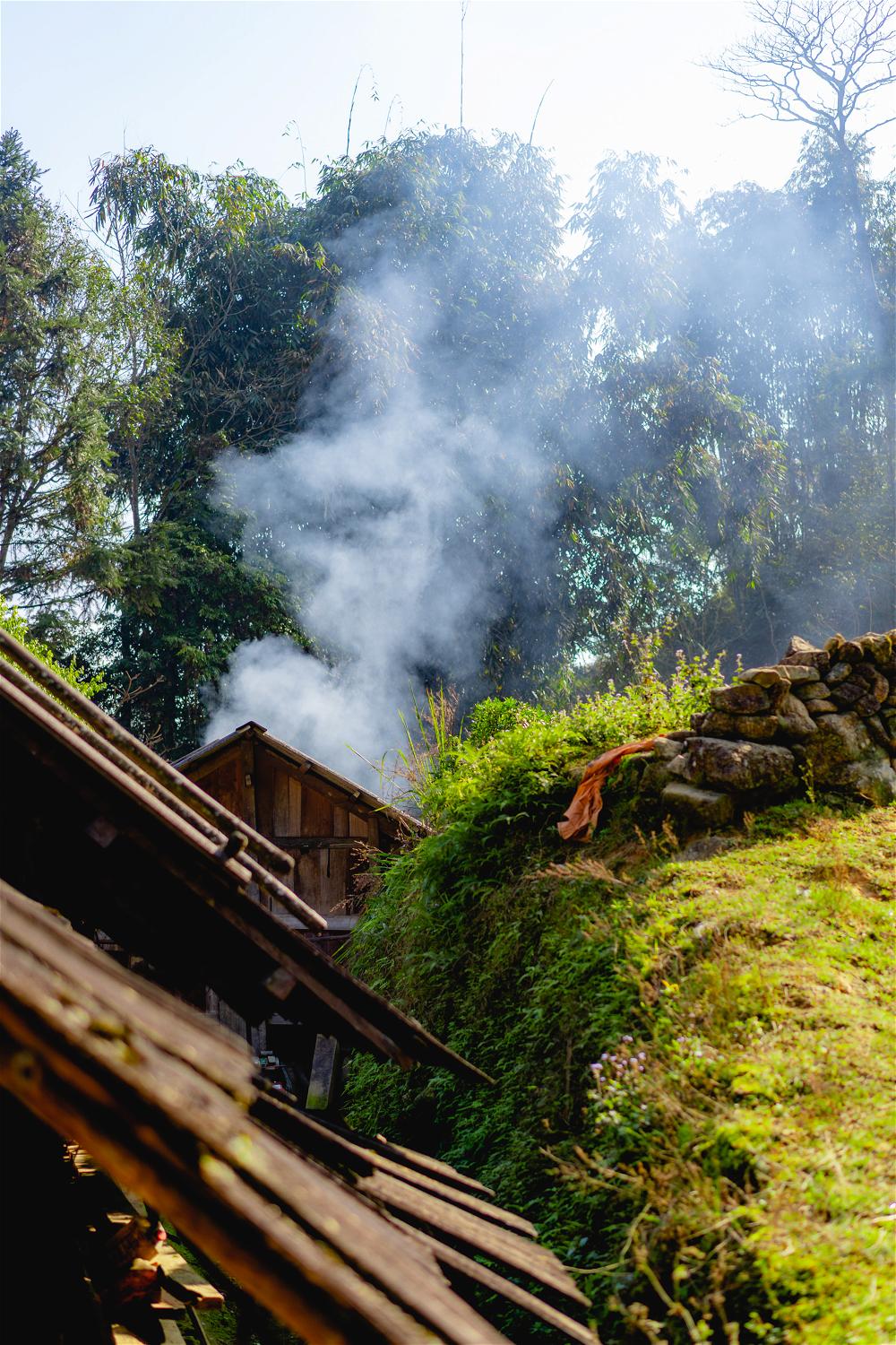 Smoke coming over traditional house near rice terraces on Sapa Vietnam trek