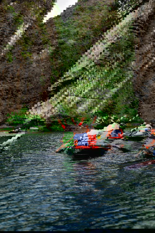 Tourists on a rowboat in the river at Trang An Ninh Binh
