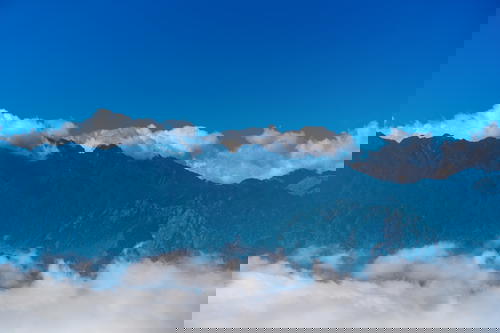 A view of the Vietnam mountain range during a Sapa trek, with clouds in the sky.