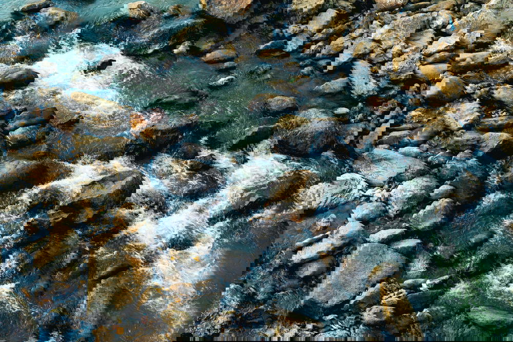 Shallow river flowing through big rocks