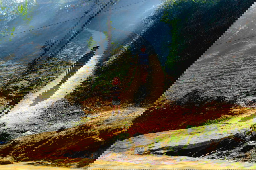 A boy and a girl hiking on a dirt path in Sapa, Vietnam.